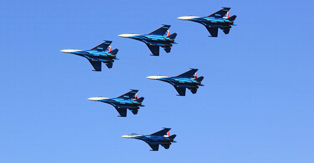 a group of fighter jets flying through a blue sky