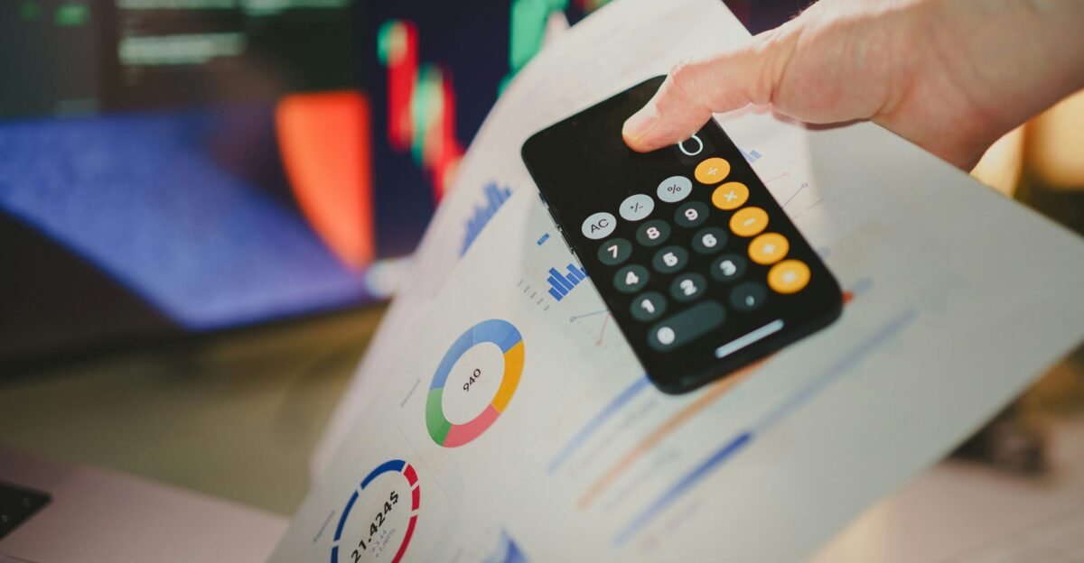 a person holding a calculator over a piece of paper