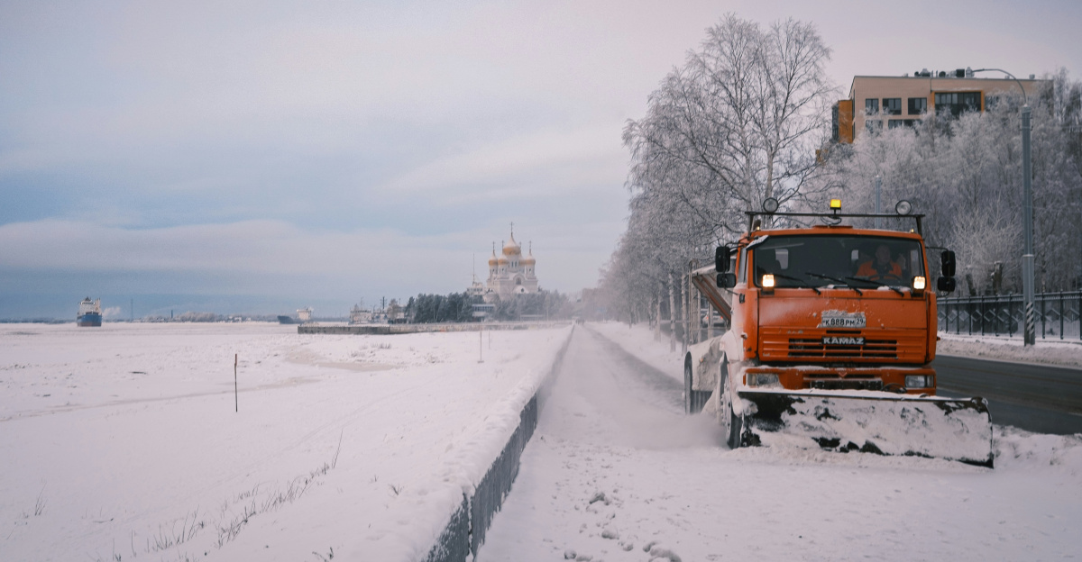 a snow plow is driving down a snowy road