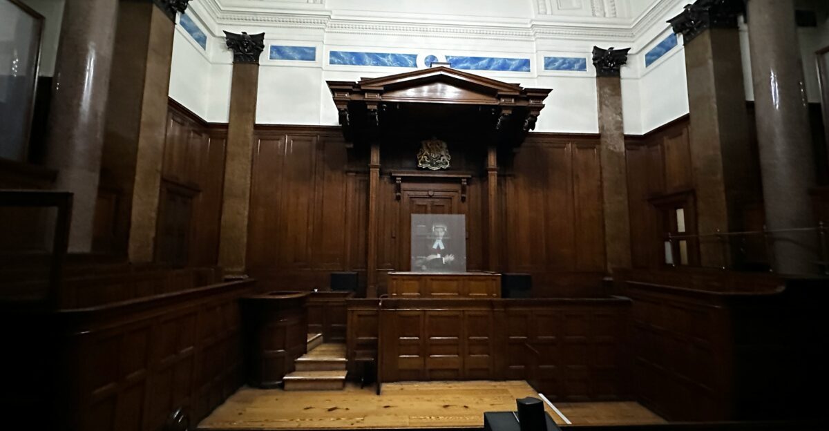 an empty courtroom with wooden paneling and columns