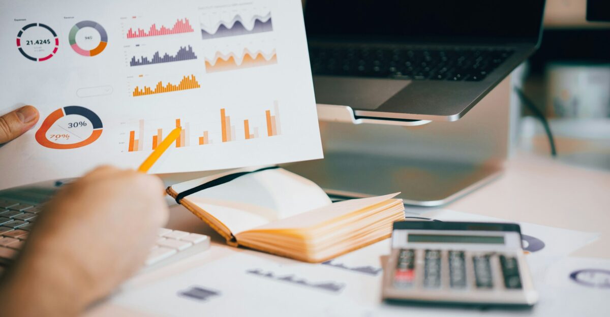 a person holding a piece of paper over a laptop