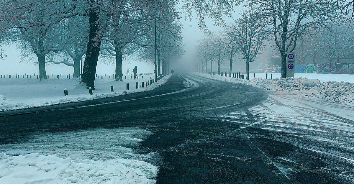 a snowy road with a stop sign on it