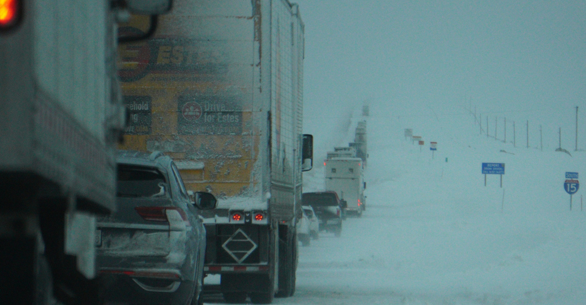 a couple of trucks driving down a snow covered road
