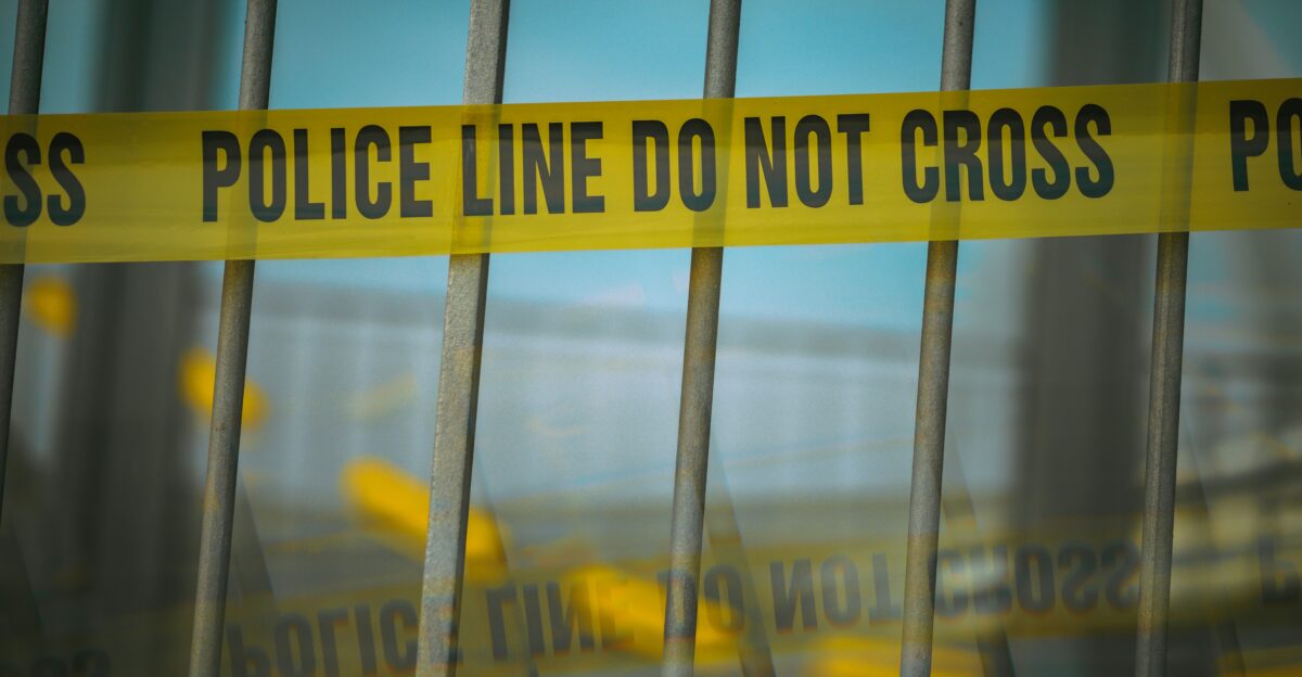 a close up of a yellow police line behind bars