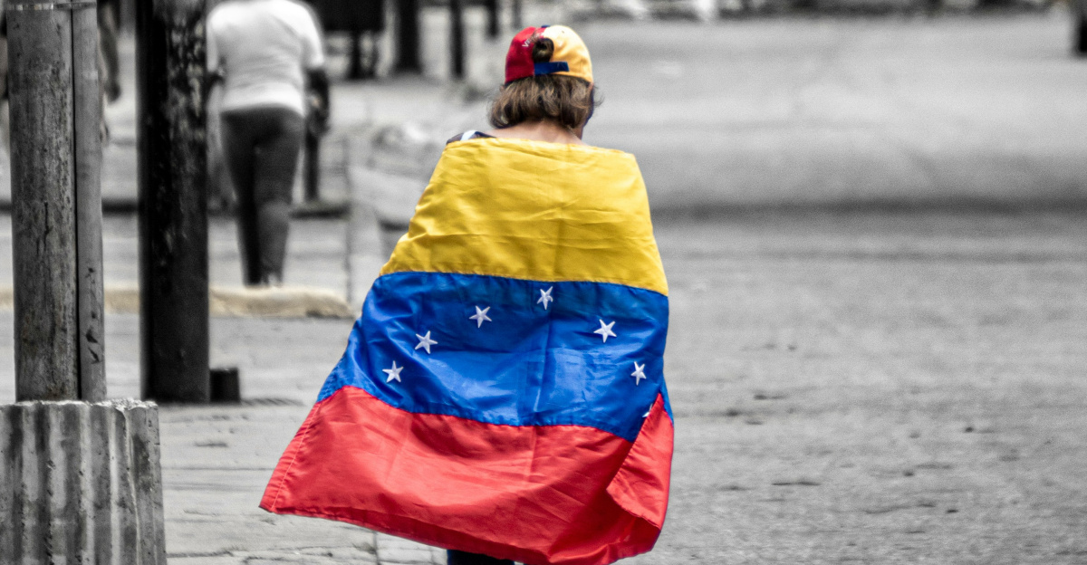 A person walking down a street holding a flag