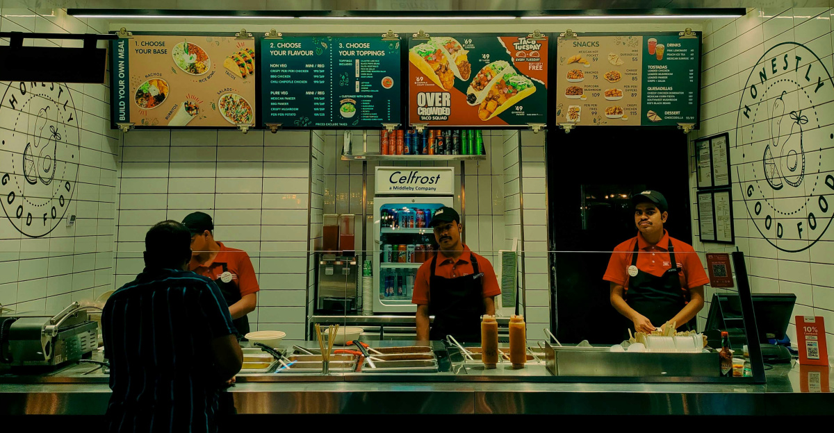 A couple of people standing in front of a restaurant