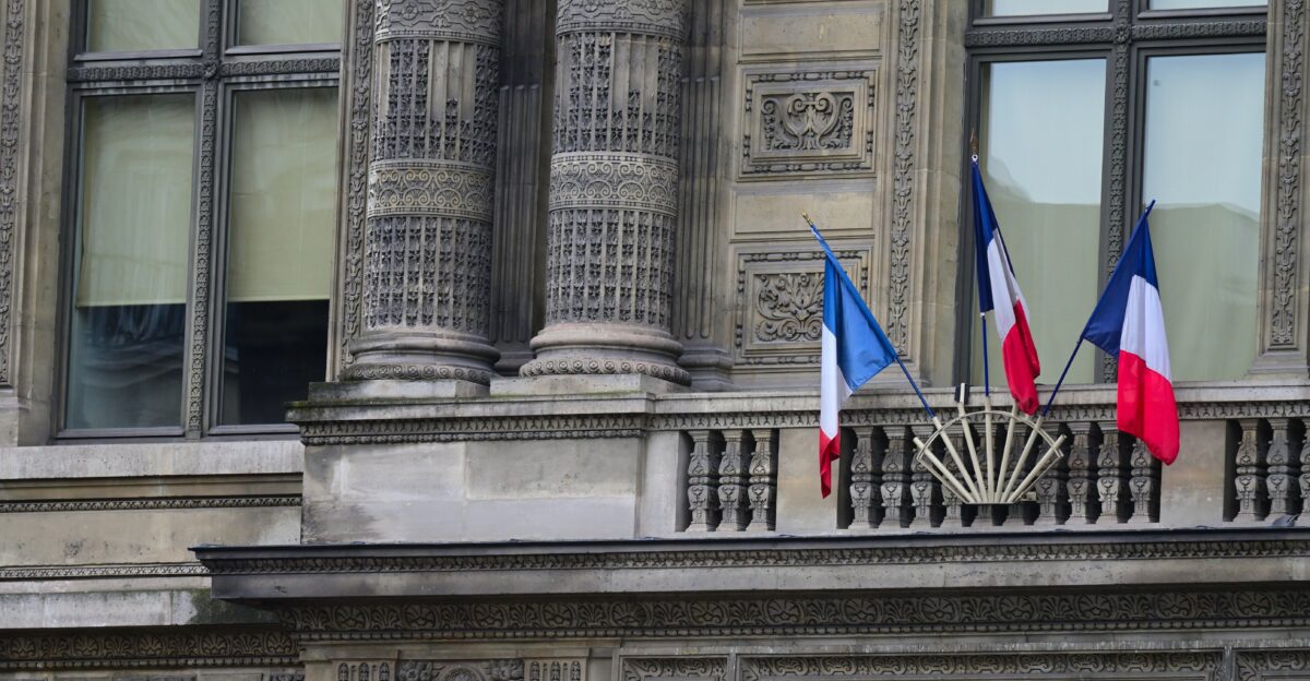A building with flags on the balcony of it