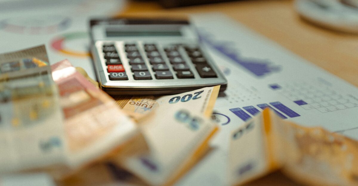 A calculator sitting on top of a pile of money
