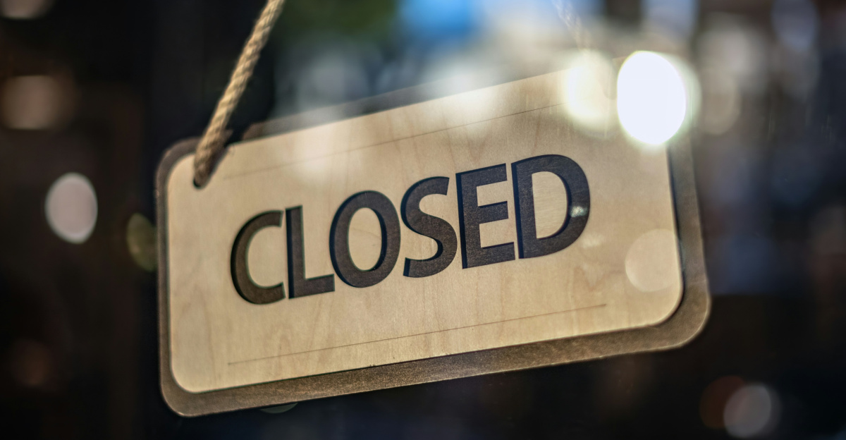 A closed sign hanging from a glass door