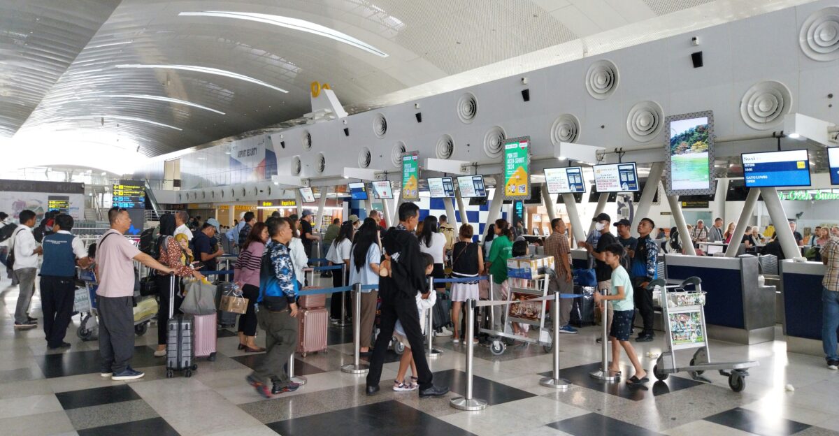 A large group of people waiting in line at an airport