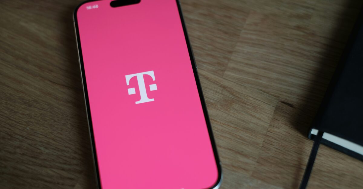 A pink phone sitting on top of a wooden table
