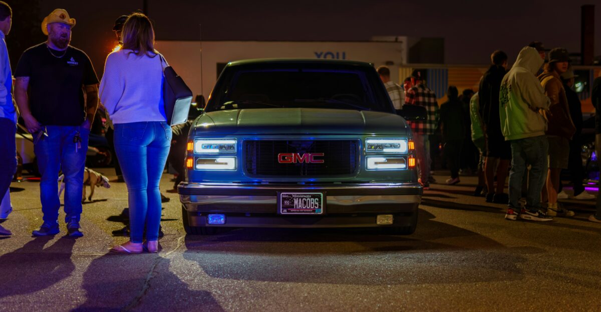A group of people standing around a car