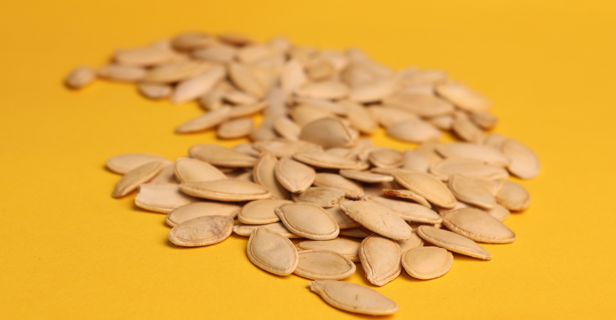 A pile of sunflower seeds on a yellow background