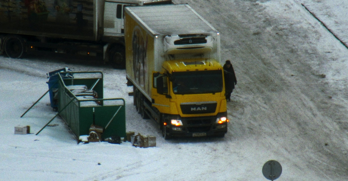 A truck is driving down a snowy road