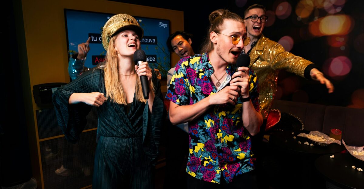 A group of people standing around each other in a room