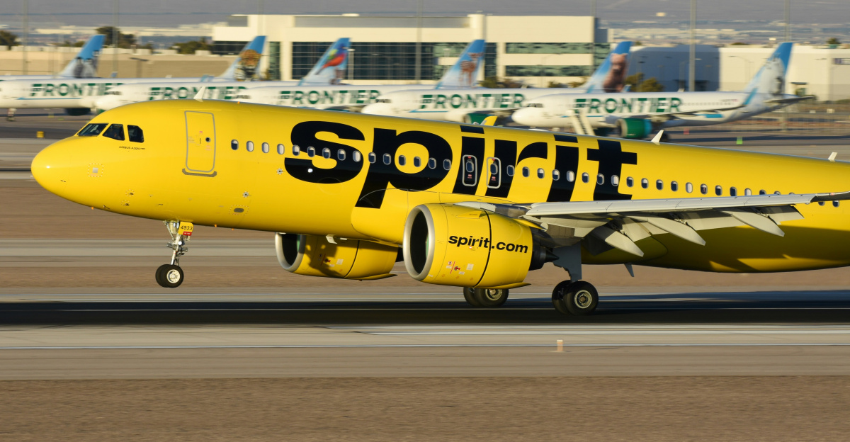 A yellow spirit airplane on the runway of an airport