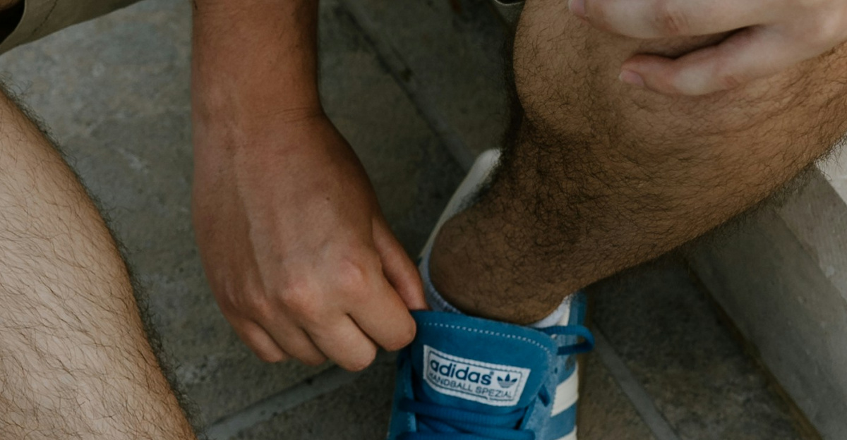 A man sitting on a ledge tying his shoes