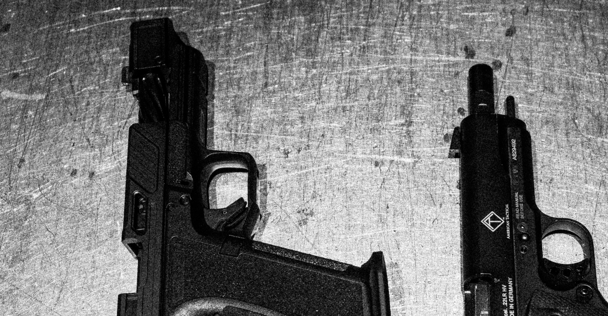 Two handguns are shown on a surface.