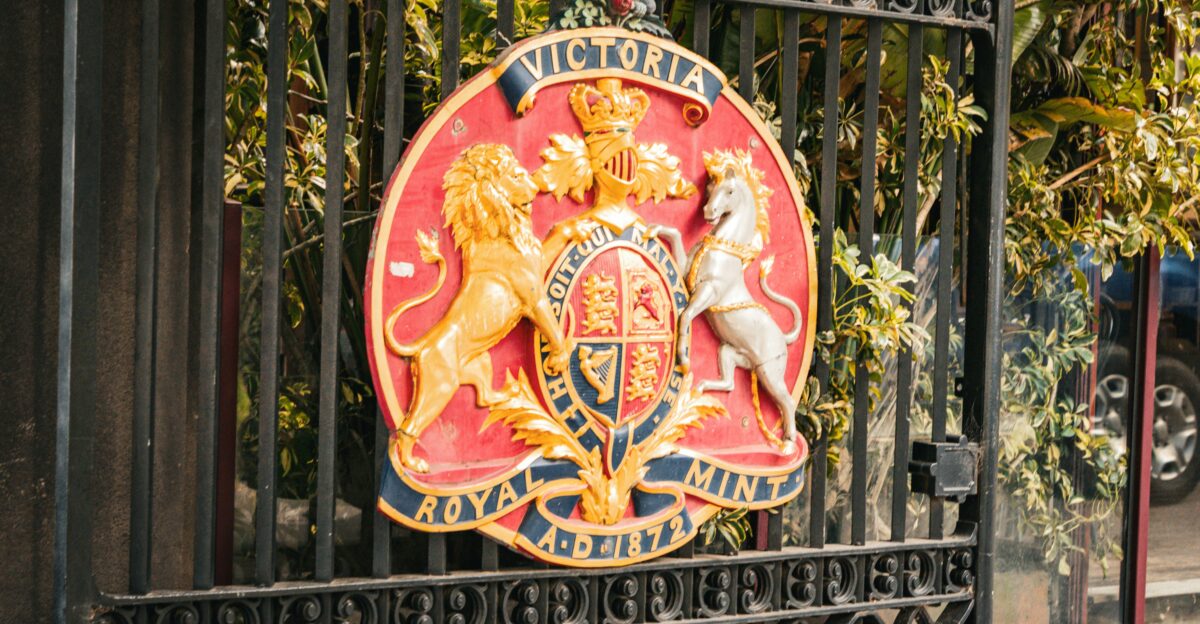 A royal coat of arms adorns a gate