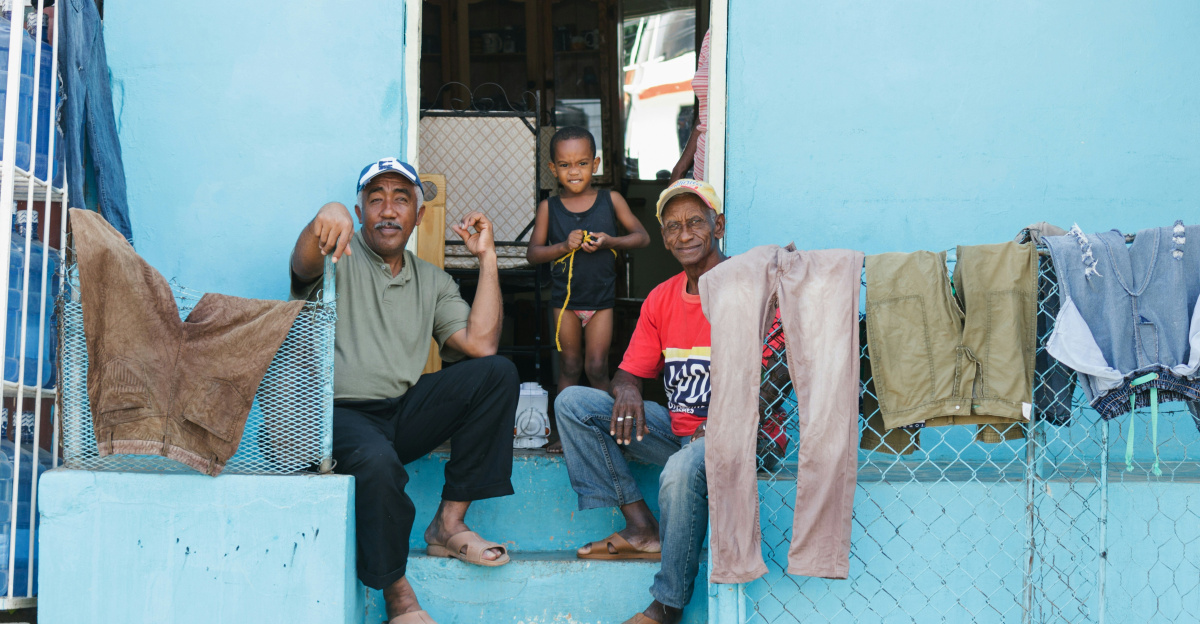 People relax on the porch of a blue house.