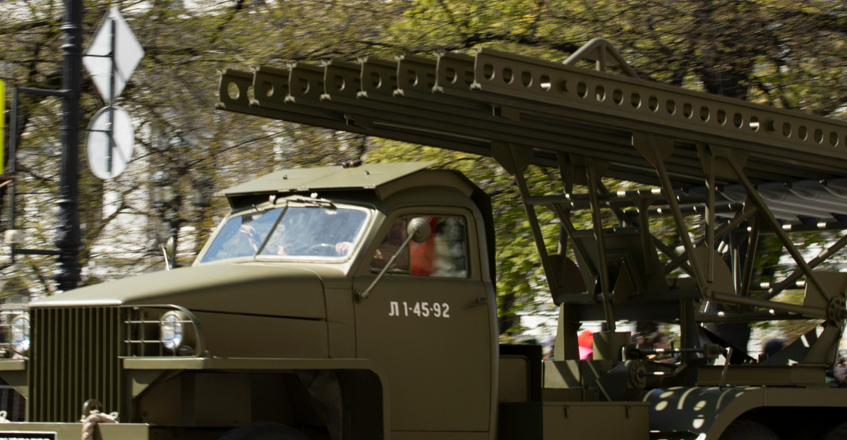 A russian military vehicle parades in the street.