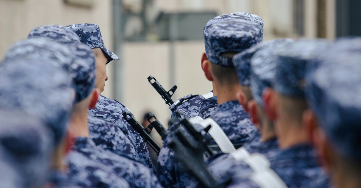 Soldiers stand in formation with rifles