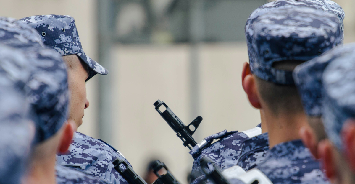 Soldiers stand in formation with rifles.