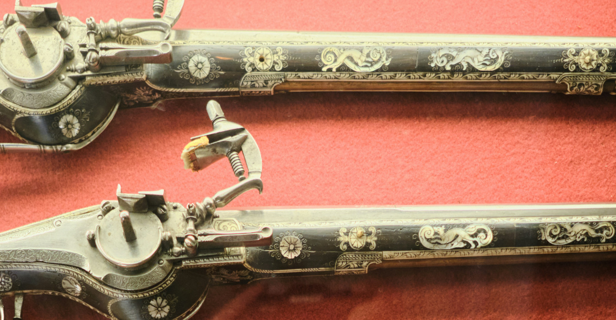 Antique pistols and tools are on display.