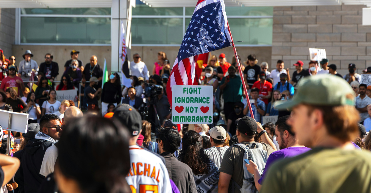 Protesters wave flags at an outdoor gathering.