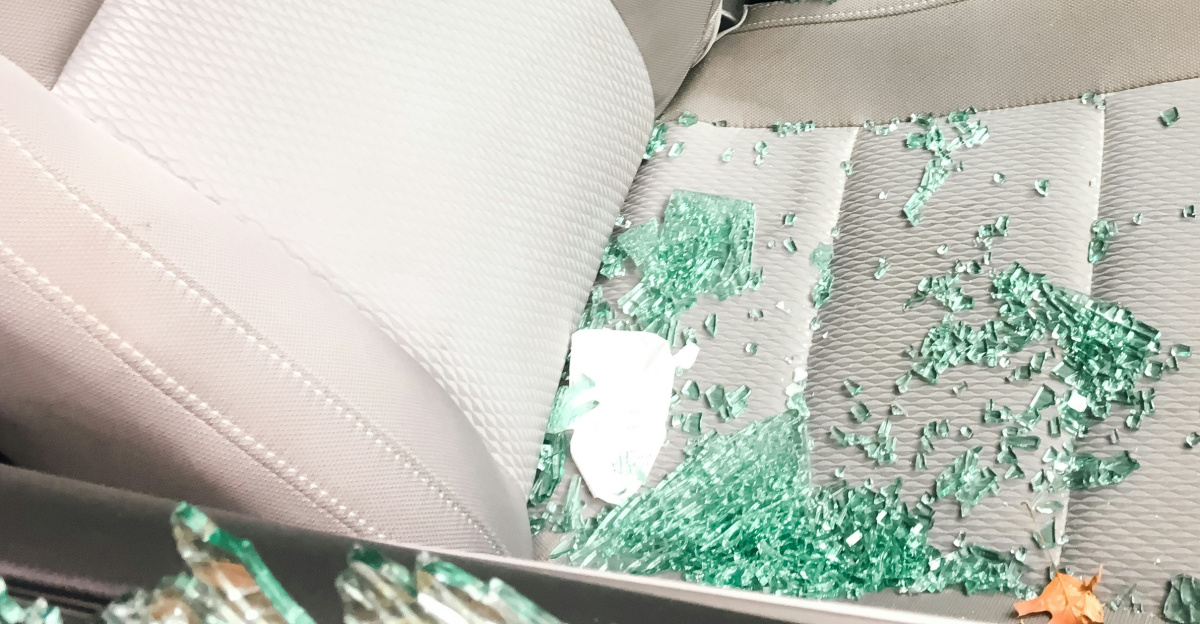 Car interior with shattered glass from a broken window.