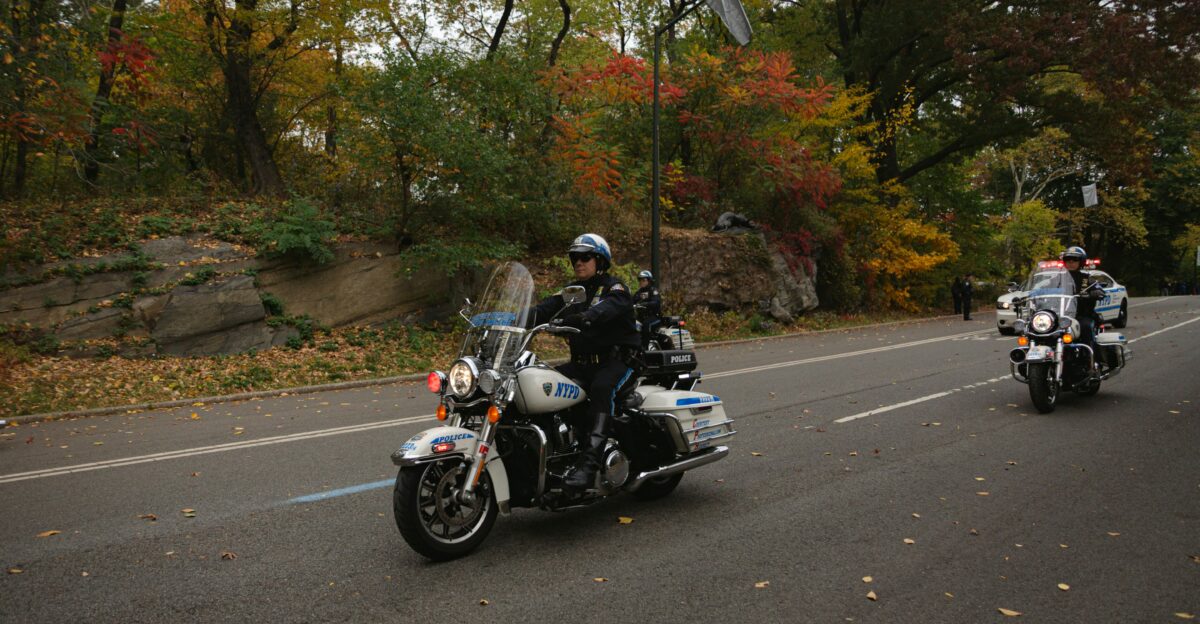 Police officers ride motorcycles on a scenic road