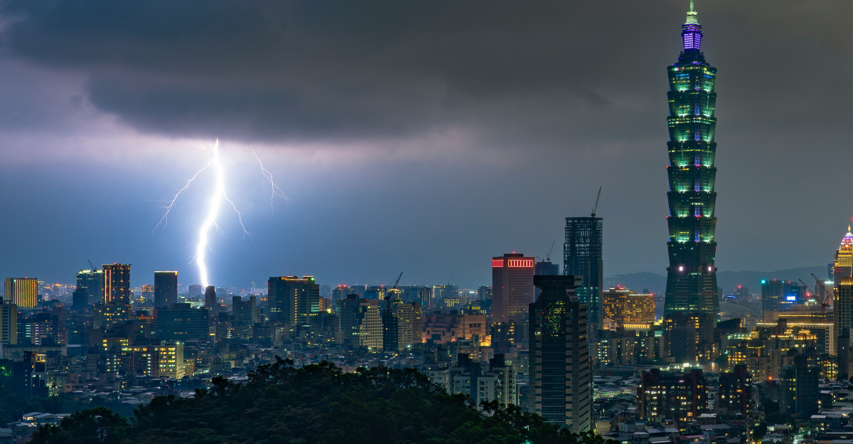 Lightning strikes over a city skyline at night.