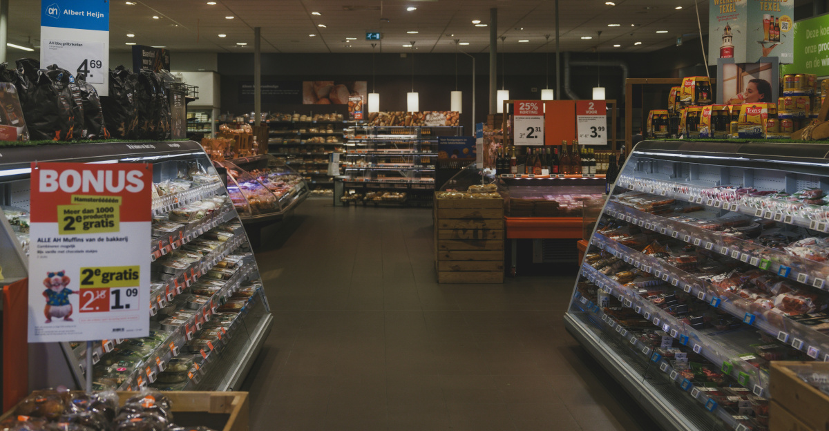 A grocery store aisle with refrigerated food displays.