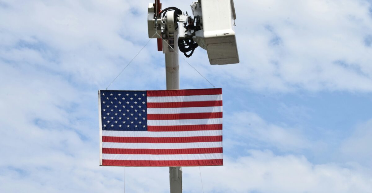 American flag on a pole with security camera