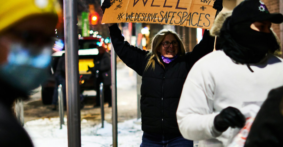Protester holds sign reading boycott the well on snowy street