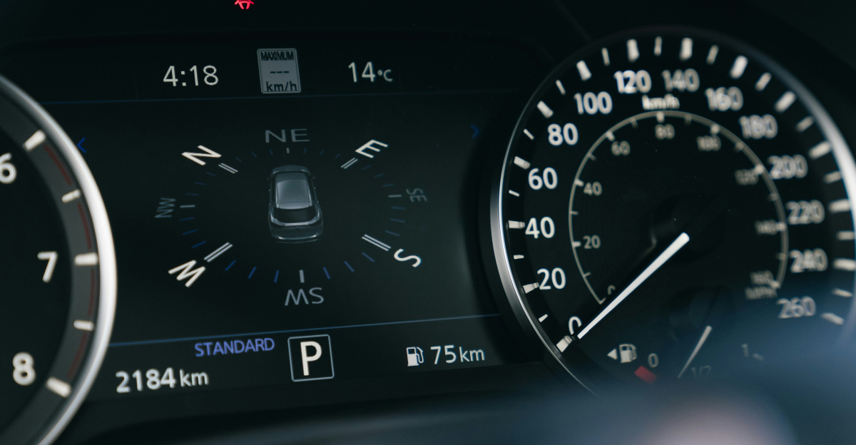 Car dashboard with speedometer and digital display.