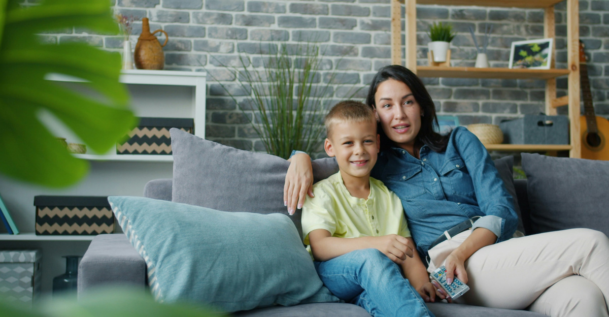 Mother and son sitting on a couch together.