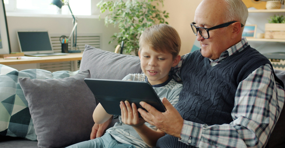Grandfather and grandson looking at tablet on tablet.