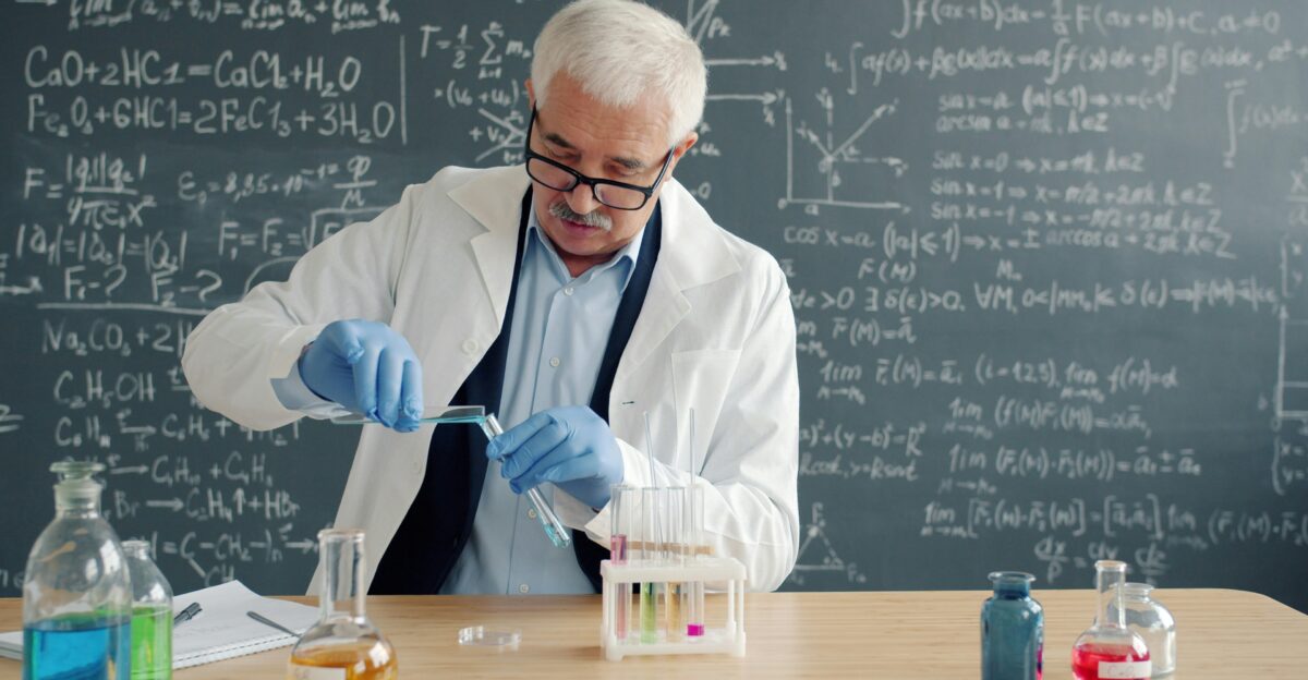 Scientist in lab coat conducts experiment with test tubes
