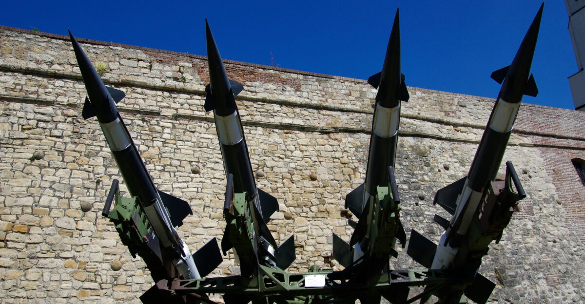 Four missiles on a launch platform with brick wall background
