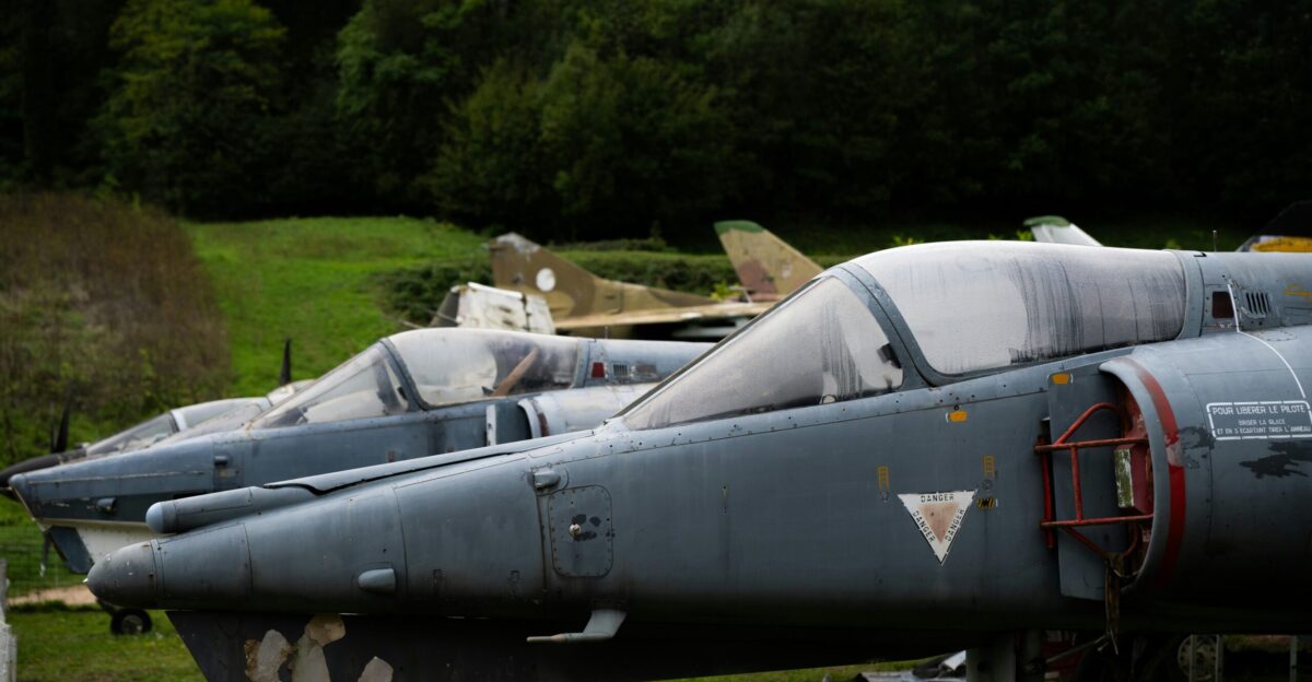 Several old fighter jets parked outdoors