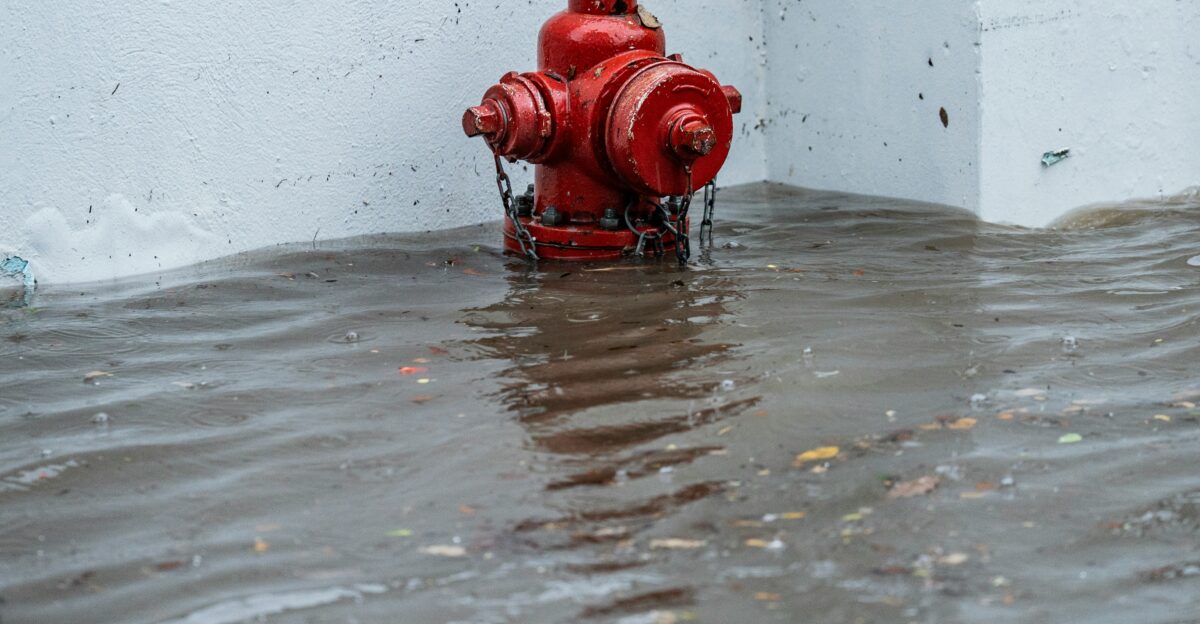 Red fire hydrant submerged in floodwaters