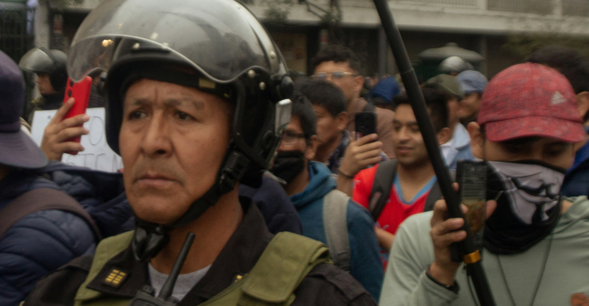 Police officer in riot gear observing a crowd