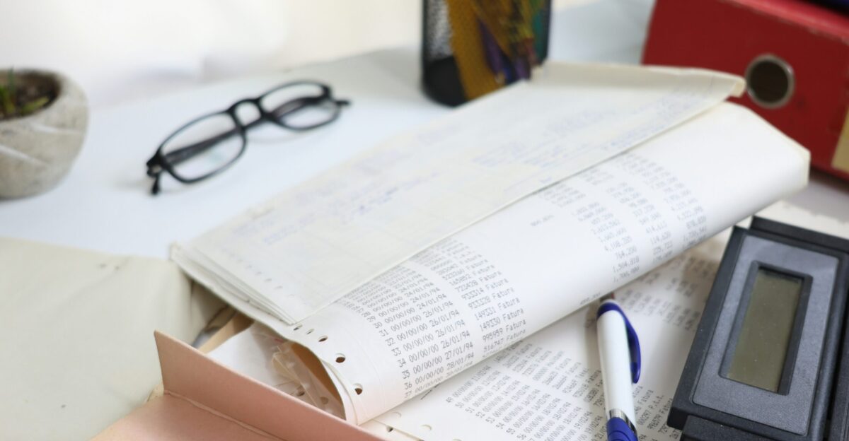 Desk with papers glasses calculator and office supplies