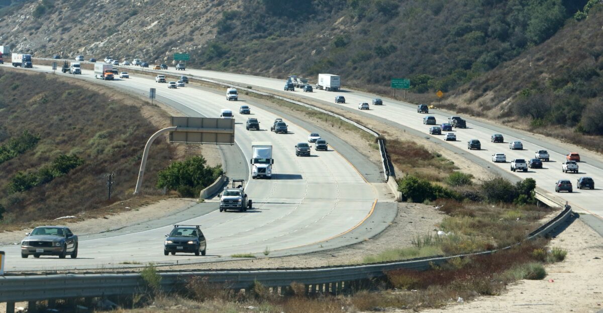 Cars driving on a multi-lane highway through hills