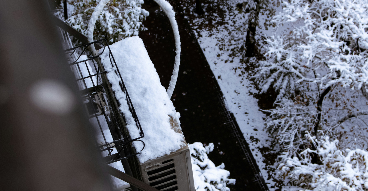 Snow covered industrial equipment next to trees