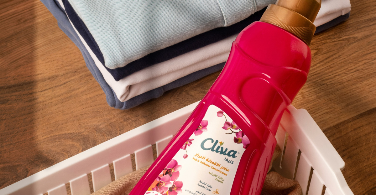 Folded clothes and a bottle of fabric softener.