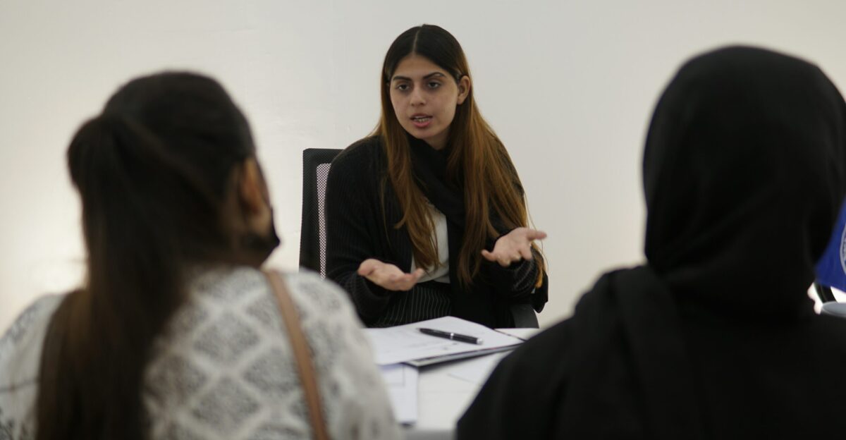 Woman gesturing while talking to two people