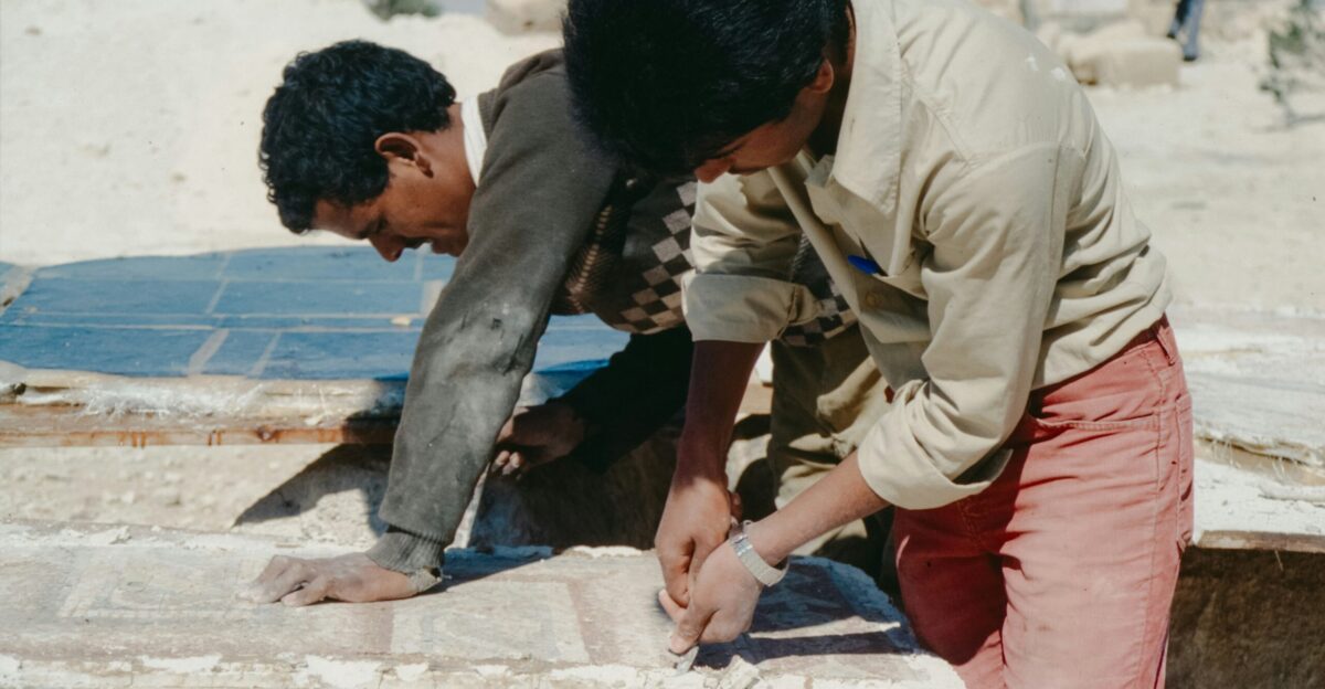 Two young men working on stone blocks outdoors