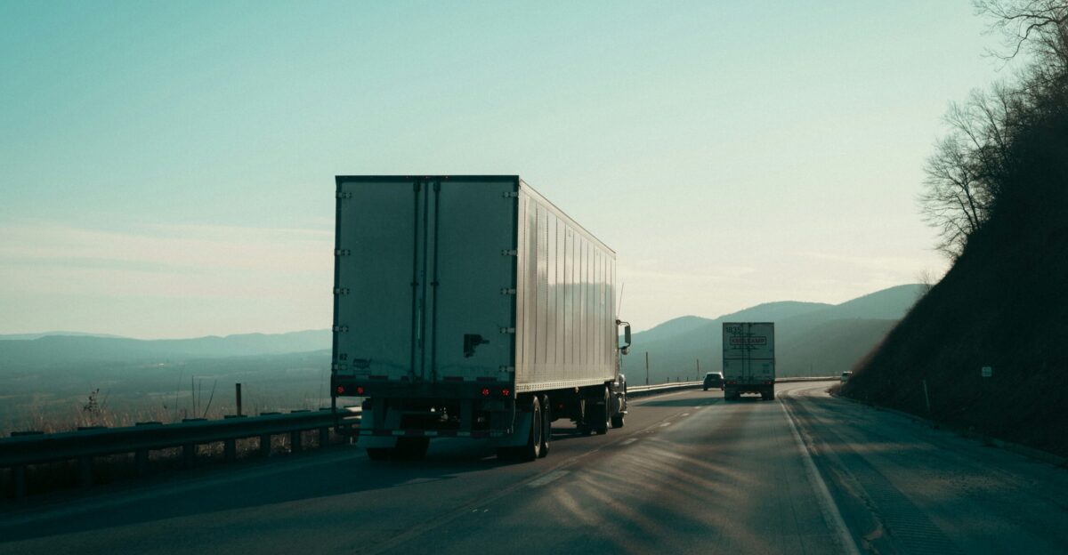Two semi-trucks driving on a highway